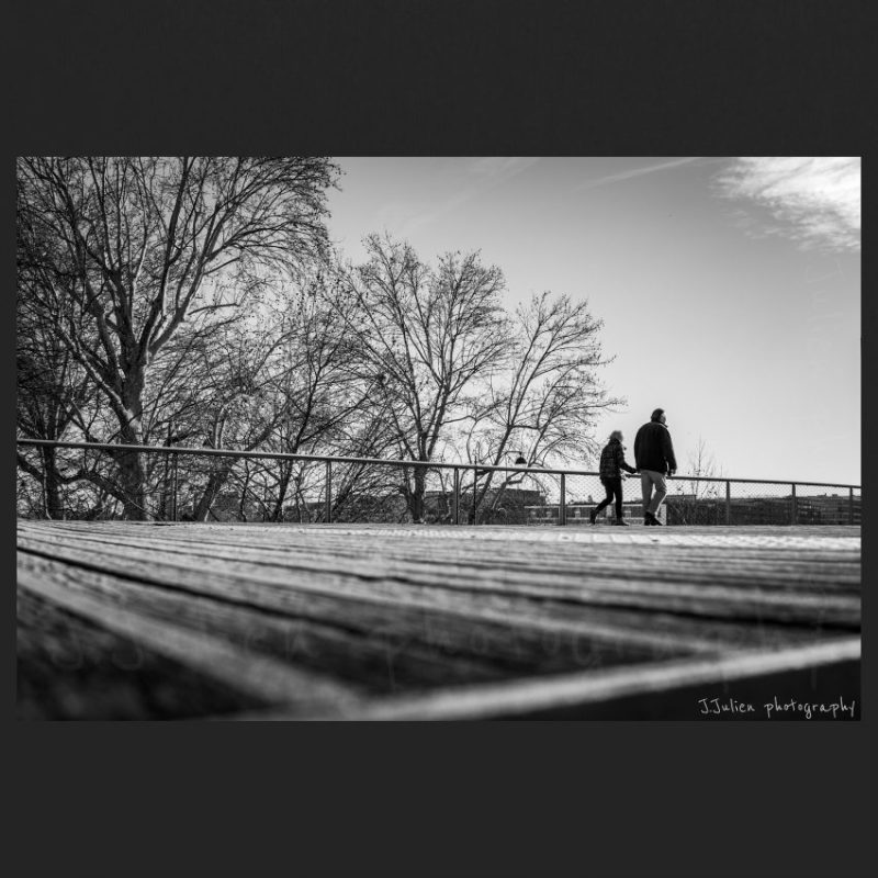 old couple walking on bridge