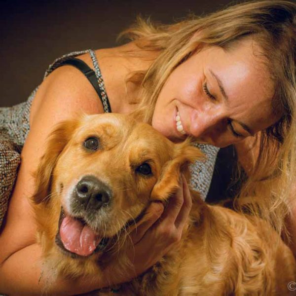 woman smiling with her golden retriever dog