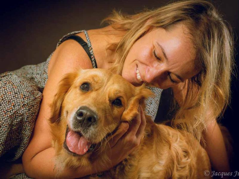 woman smiling with her golden retriever dog