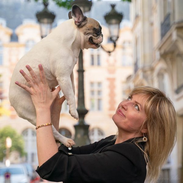blond woman hugging a french bulldog