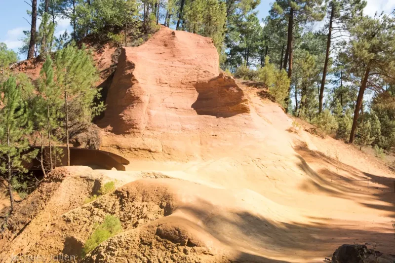 Formation rocheuse ocre rouge orange avec motifs d'érosion naturelle dans paysage forestier sur le sentier des ocres à Roussillon